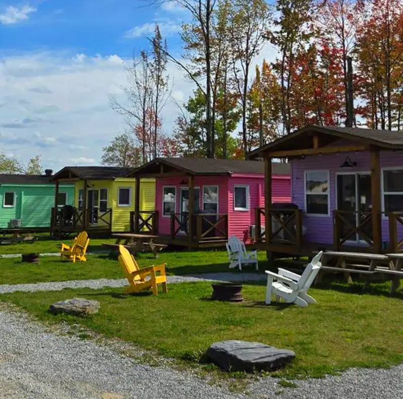 Rangée de cabanas colorées et chaises Adirondack