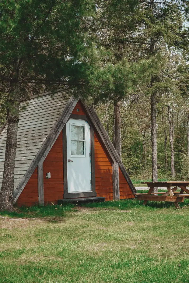 Tente en bois en A, sous les arbres